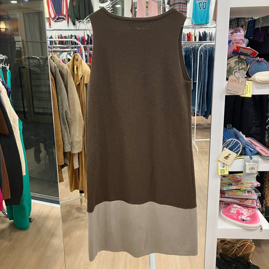 Brown sleeveless dress on a rack in a store setting with clothes and shelves in the background