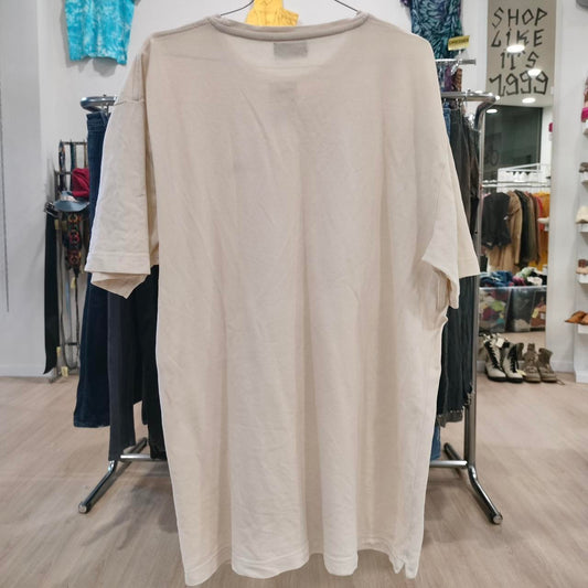 Beige long-sleeve shirt on a hanger in a store setting