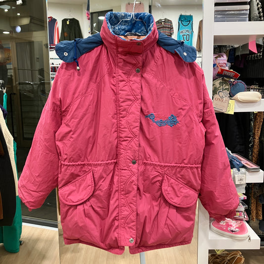 Pink children's coat with blue lining on a hanger in a store setting