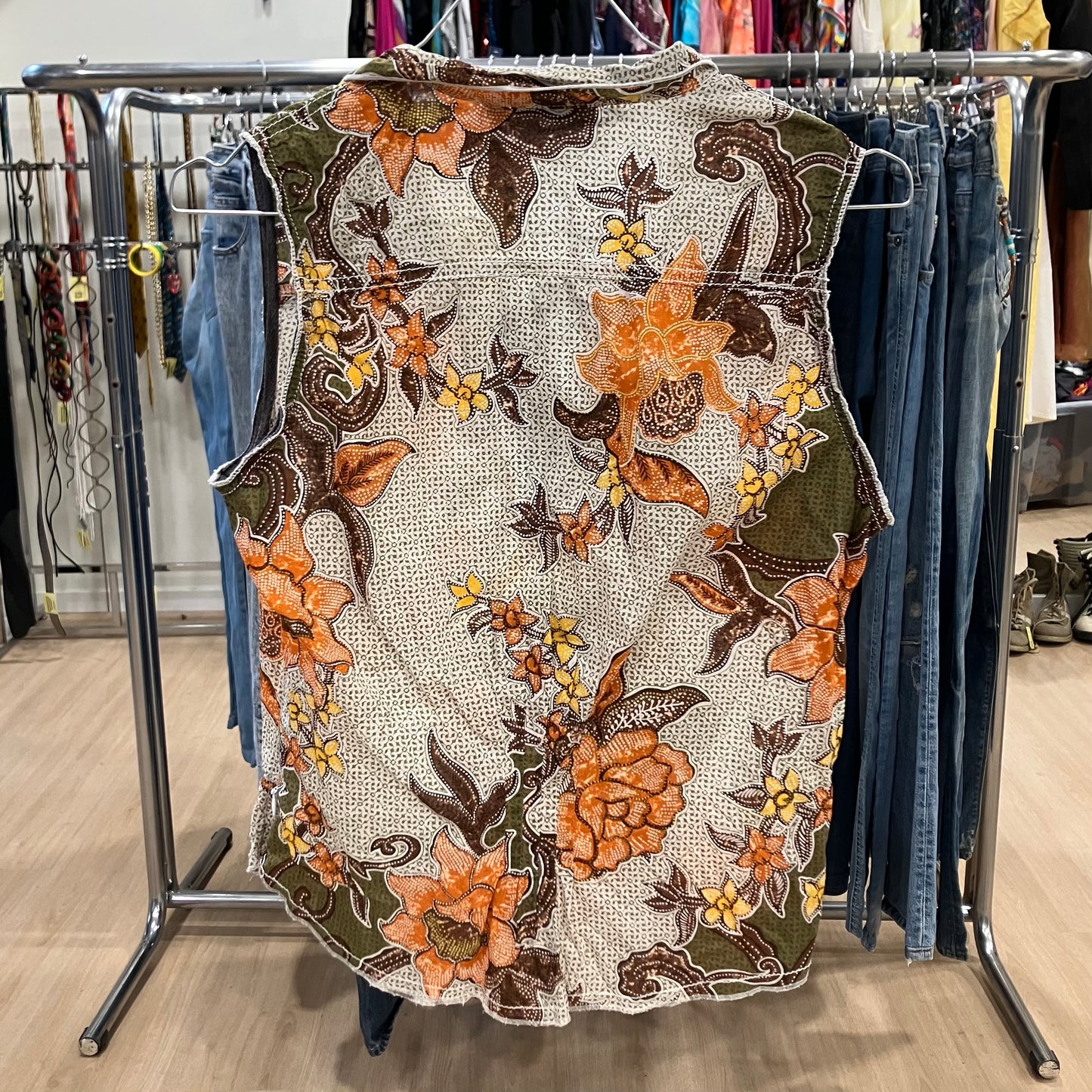Floral embroidered dress on a rack with jeans in the background