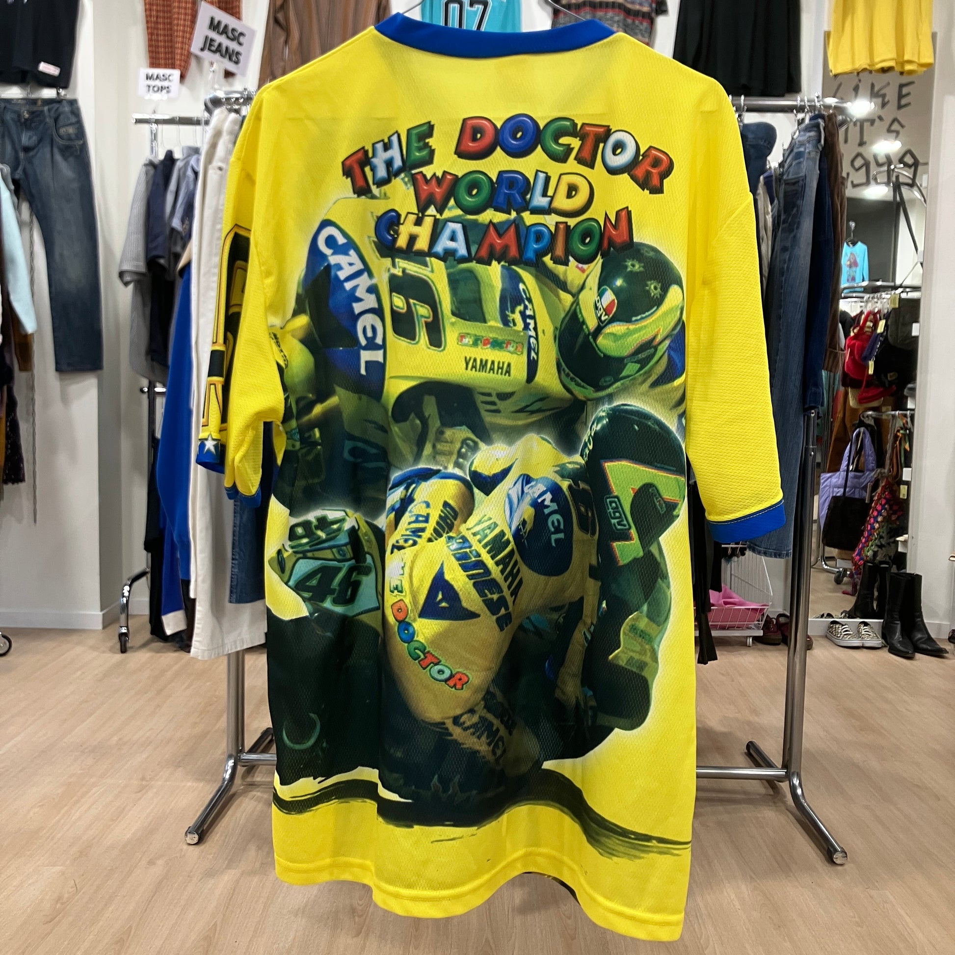Yellow t-shirt with colorful graphics and text on a rack in a store