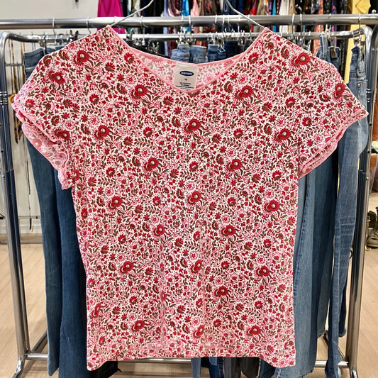 Red floral-patterned shirt on a clothing rack with jeans