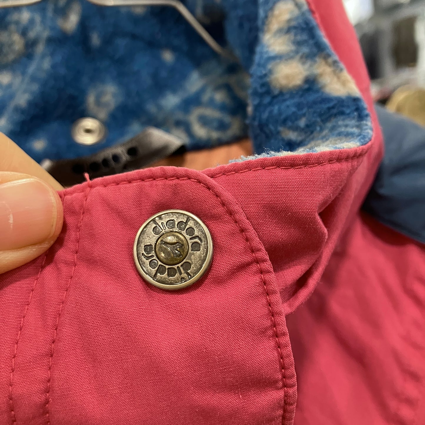 Close-up of a red jacket with a decorative button and blue interior lining