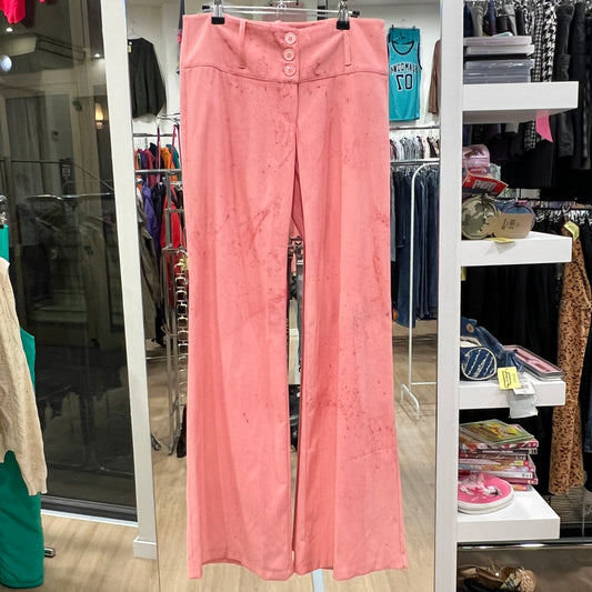 Pink pants hanging in a store with various clothing items in the background