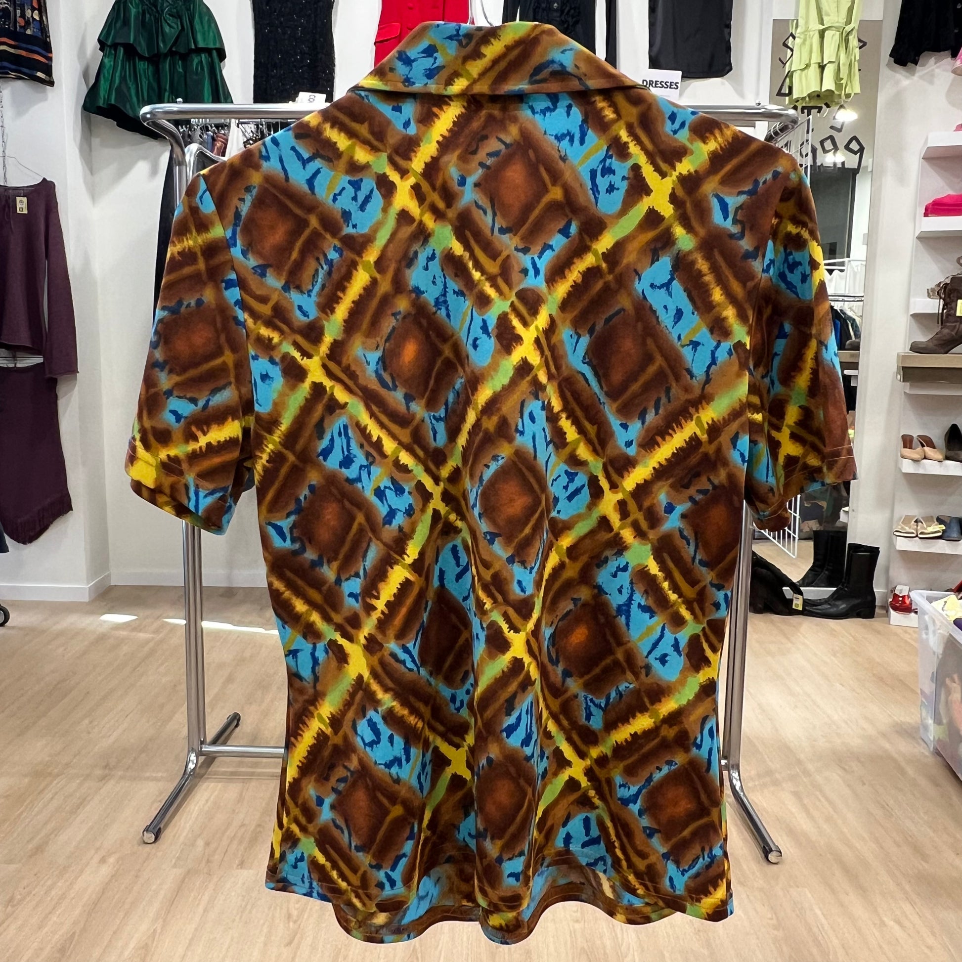 Colorful patterned shirt on a hanger in a store setting
