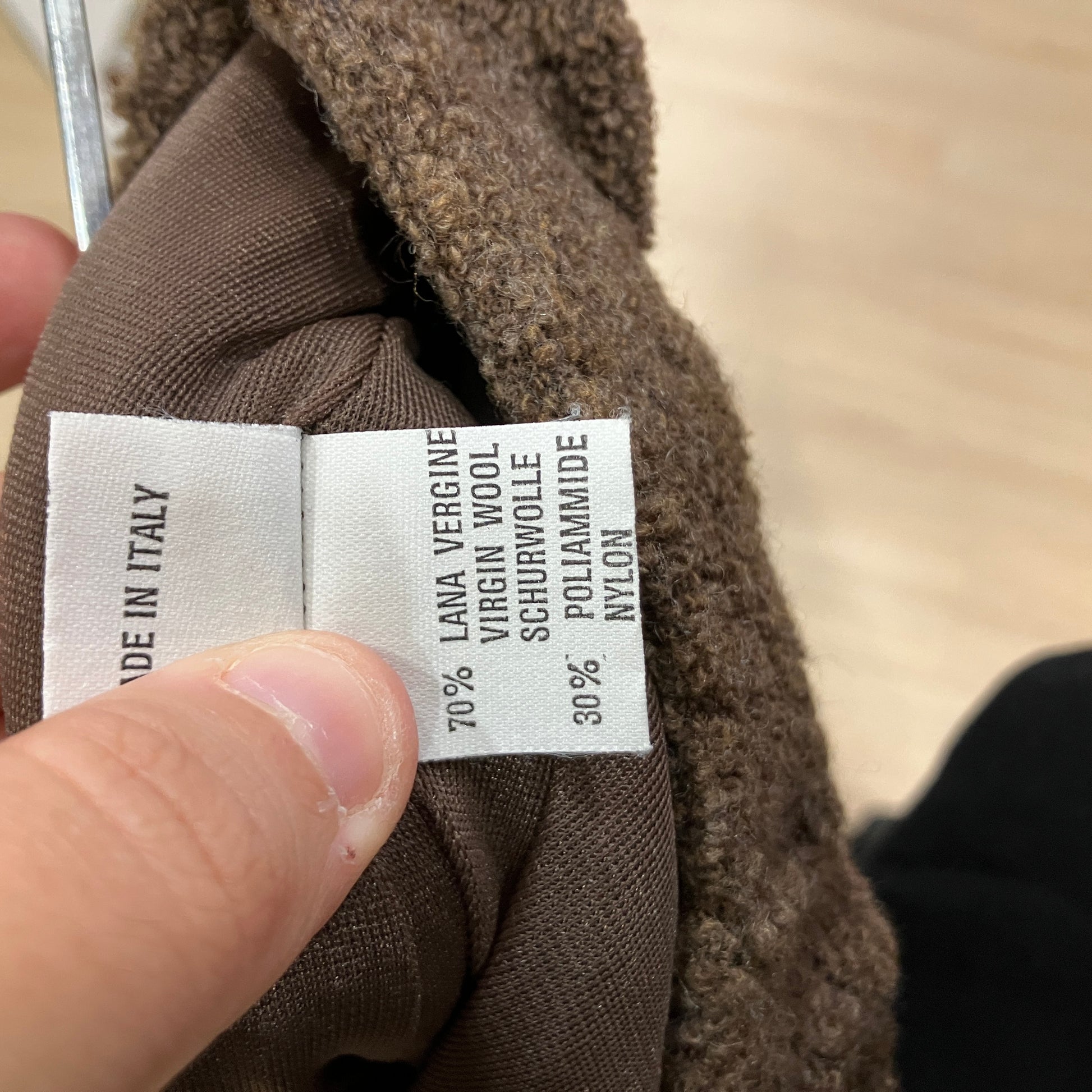 Clothing label on a brown fabric with text details