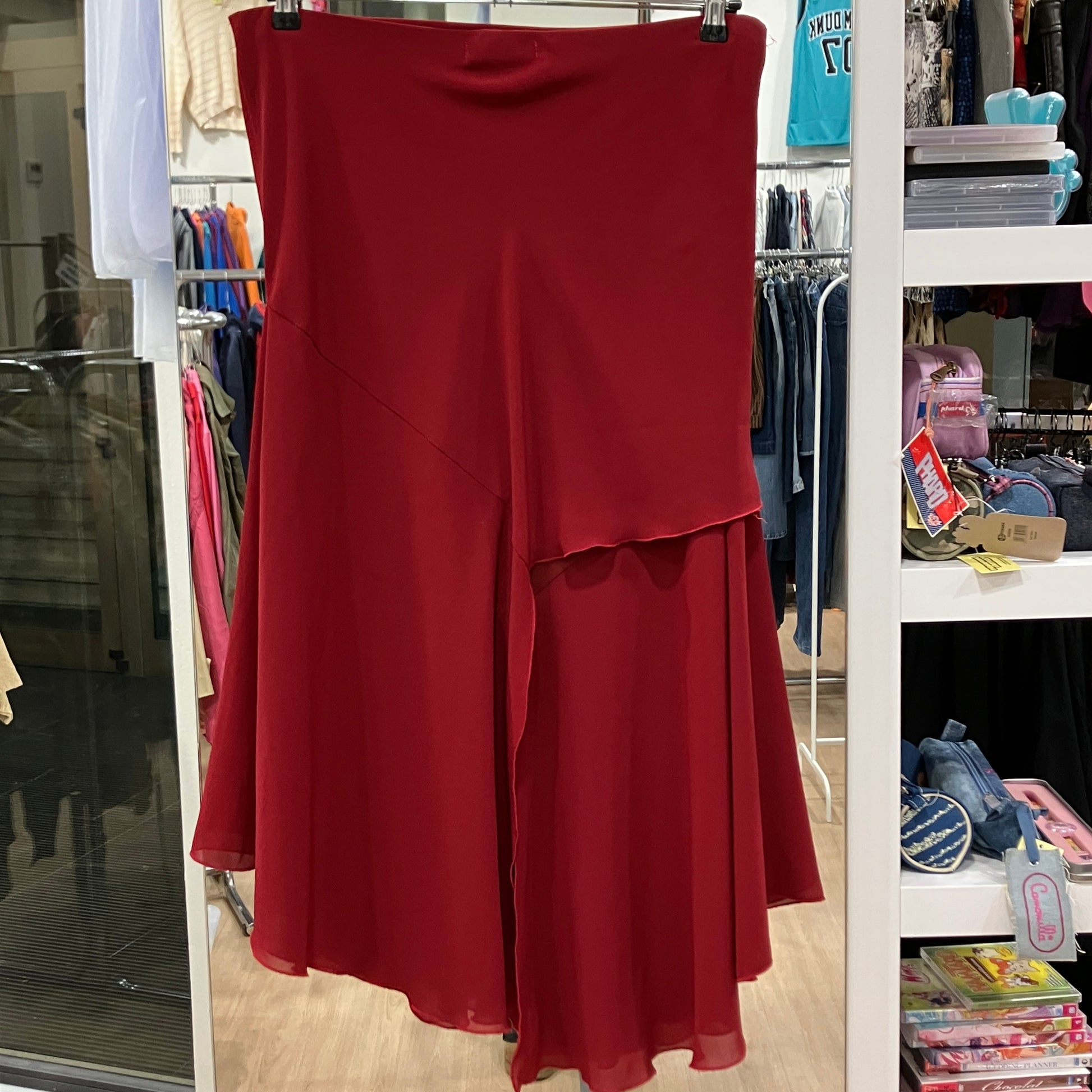 Red skirt hanging on a rack in a store setting