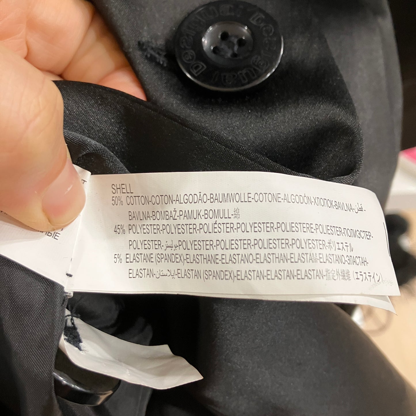 Clothing label on a black coat with visible text