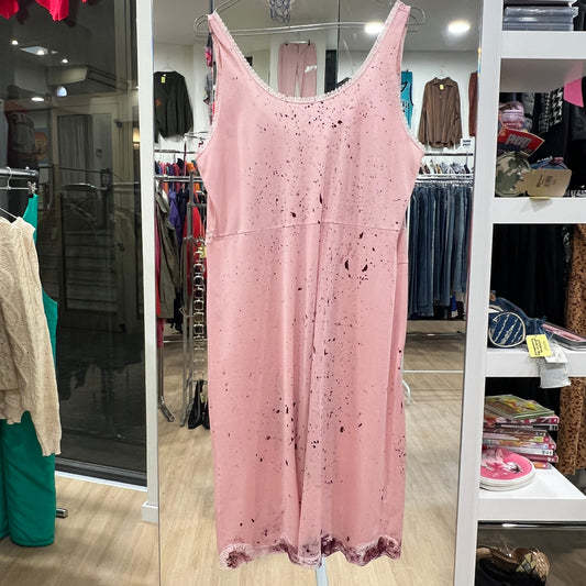 Pink sleeveless dress with black speckles hanging in a store