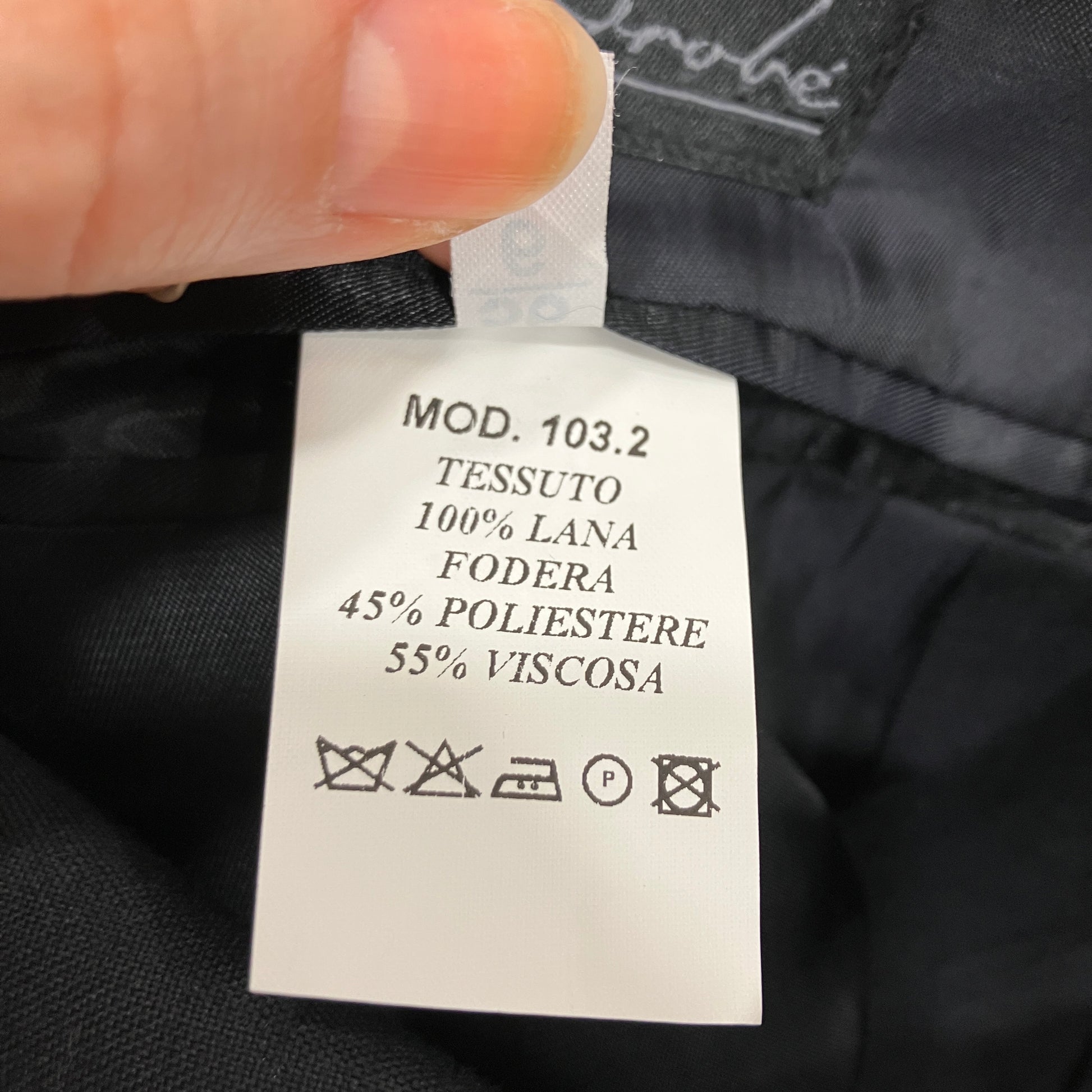 Clothing label with fabric composition details on a black garment