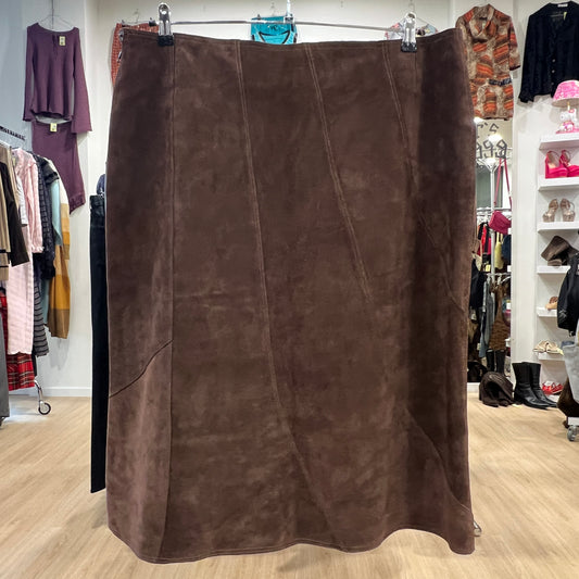 Brown suede skirt displayed in a clothing store with various garments in the background