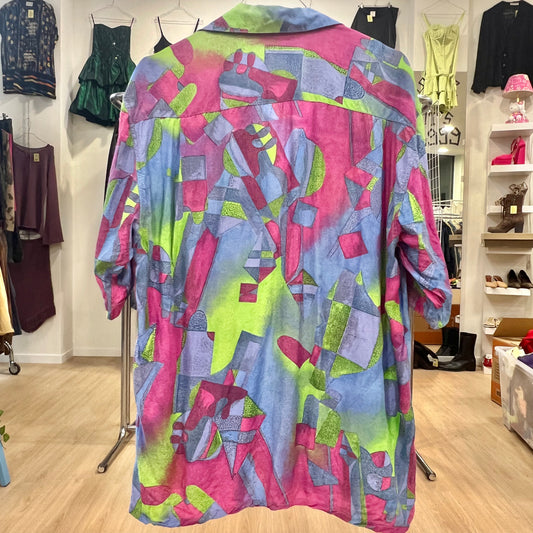 Colorful geometric-patterned shirt on a hanger in a clothing store