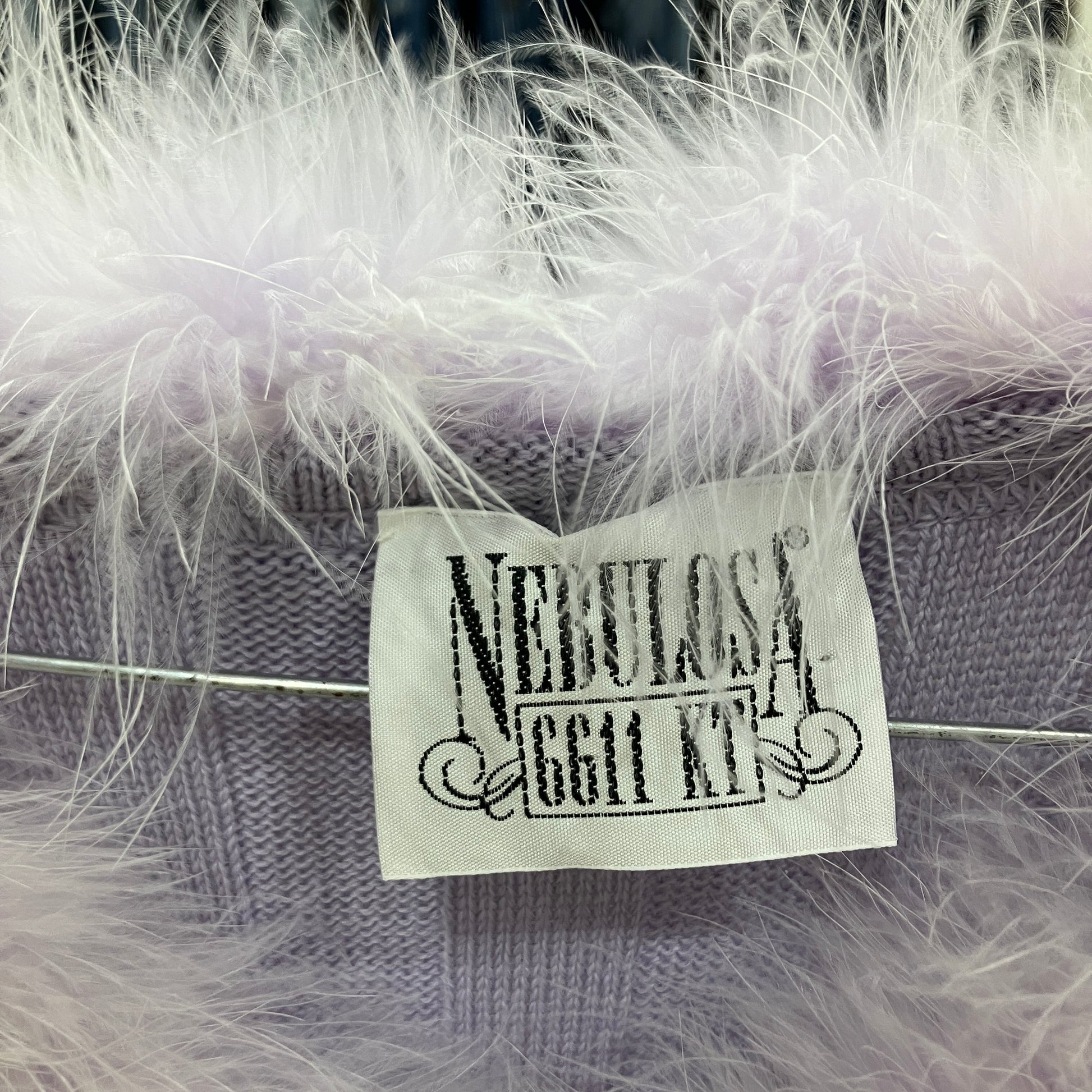 Label on a product with 'Nebulosa' text, surrounded by white feathers