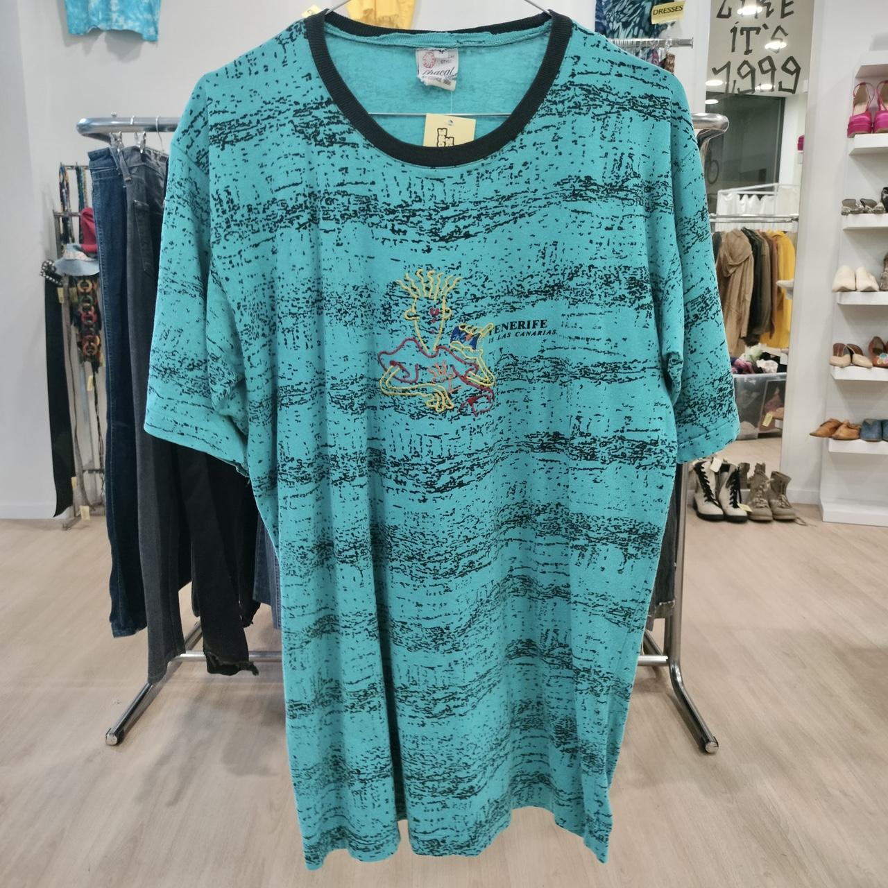 Teal dress with black accents on a rack in a store setting