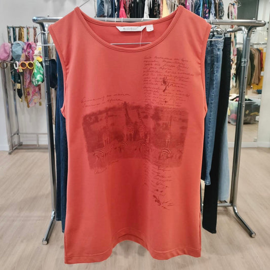 Orange sleeveless shirt with graphic design on a clothing rack