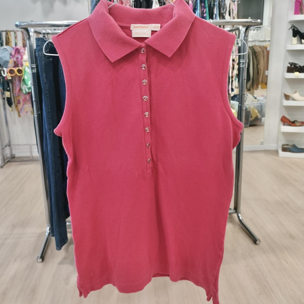 Pink sleeveless polo shirt on a rack in a store setting