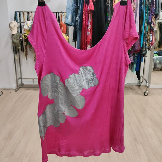 Pink dress with gray floral design hanging in a store