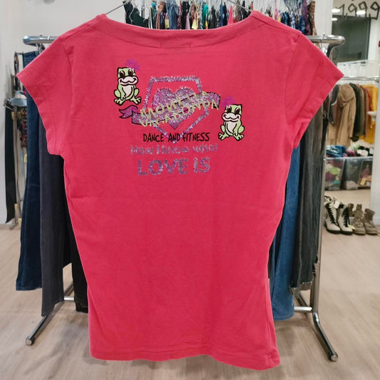 Pink t-shirt with graphic design and text on a clothing rack