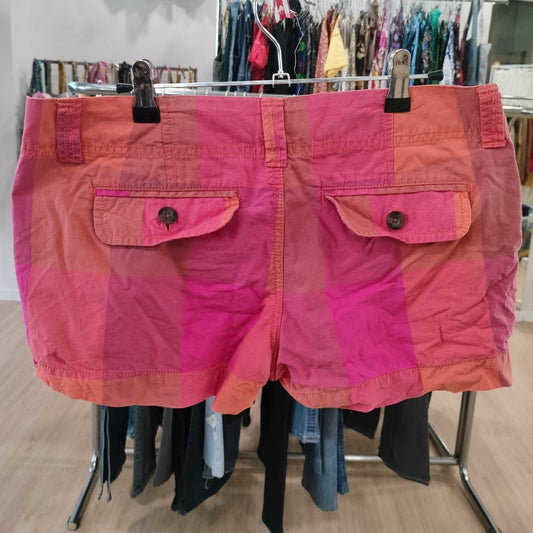 Pink shorts on a rack with other clothing in the background