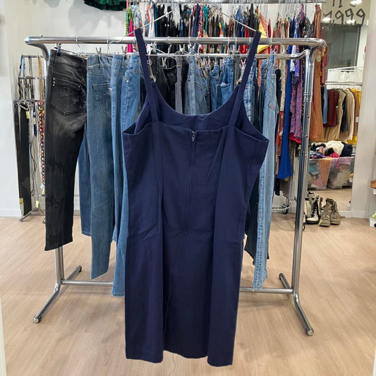 Navy blue dress on a clothing rack with jeans in a store setting