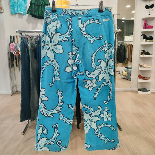 Blue pants with white floral patterns hanging on a rack in a store