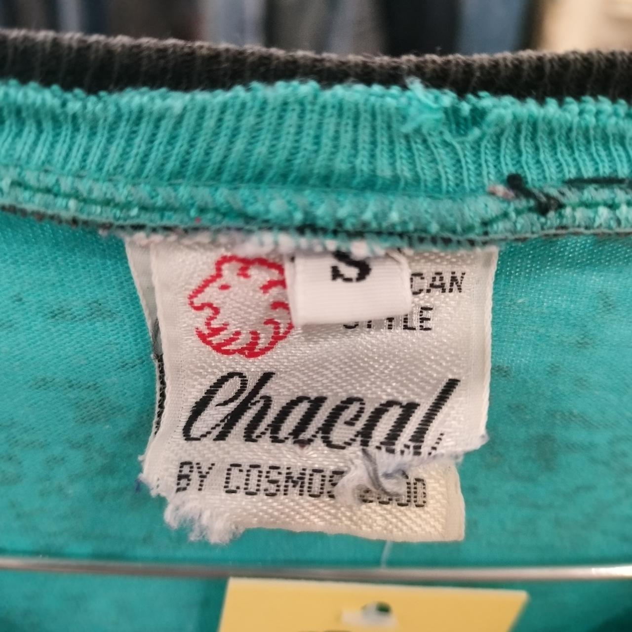 Close-up of a Chacal brand label on a teal fabric background