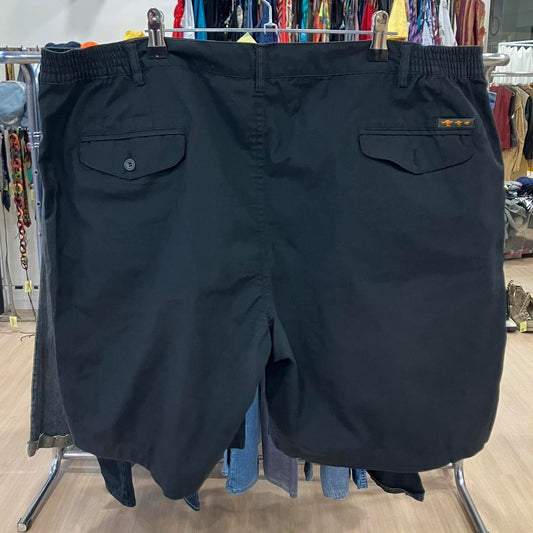 Black shorts hanging on a rack in a store setting